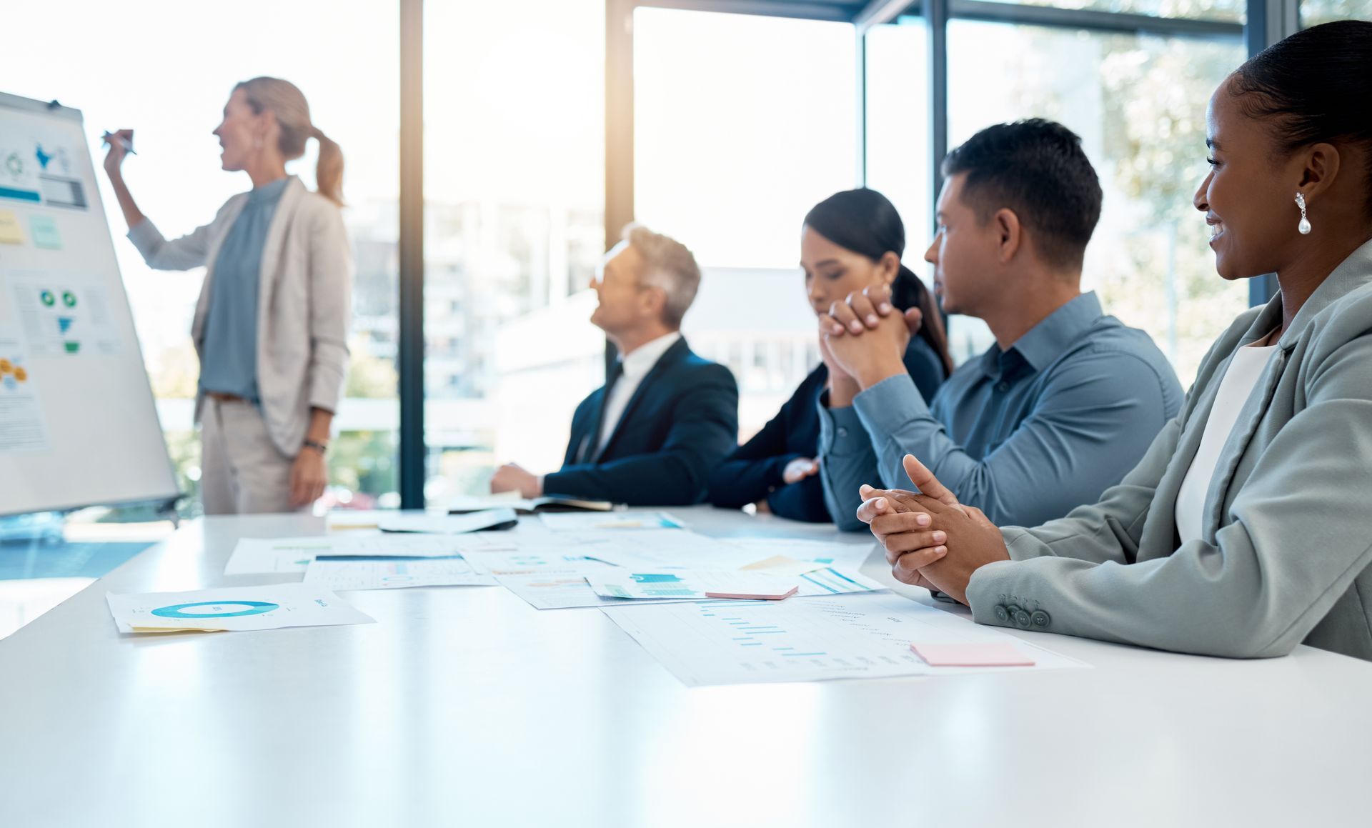 a woman is giving a presentation to a group of people in a conference room .