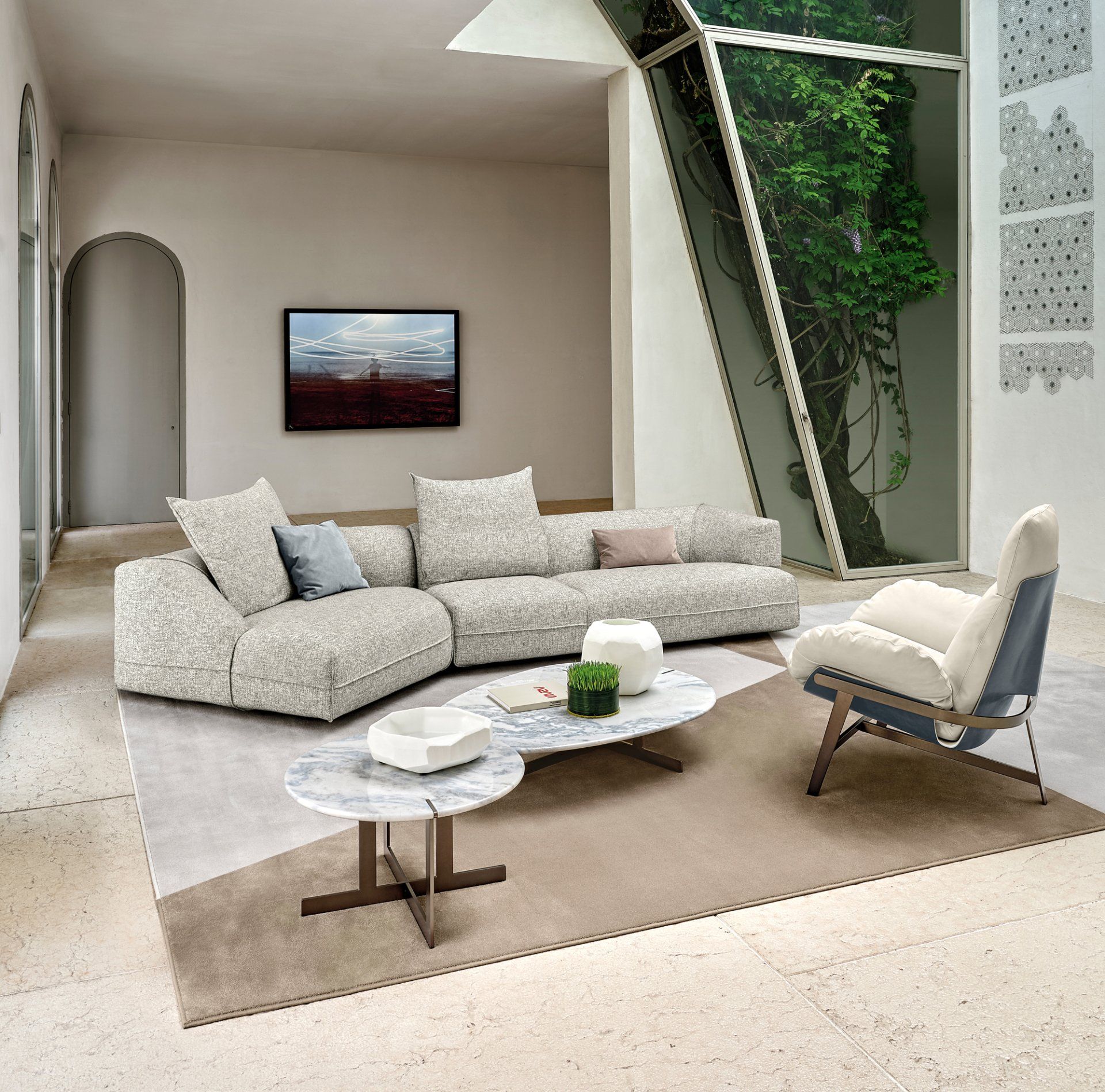 Modern living room with beige sectional, coffee table, accent chair, and wall art