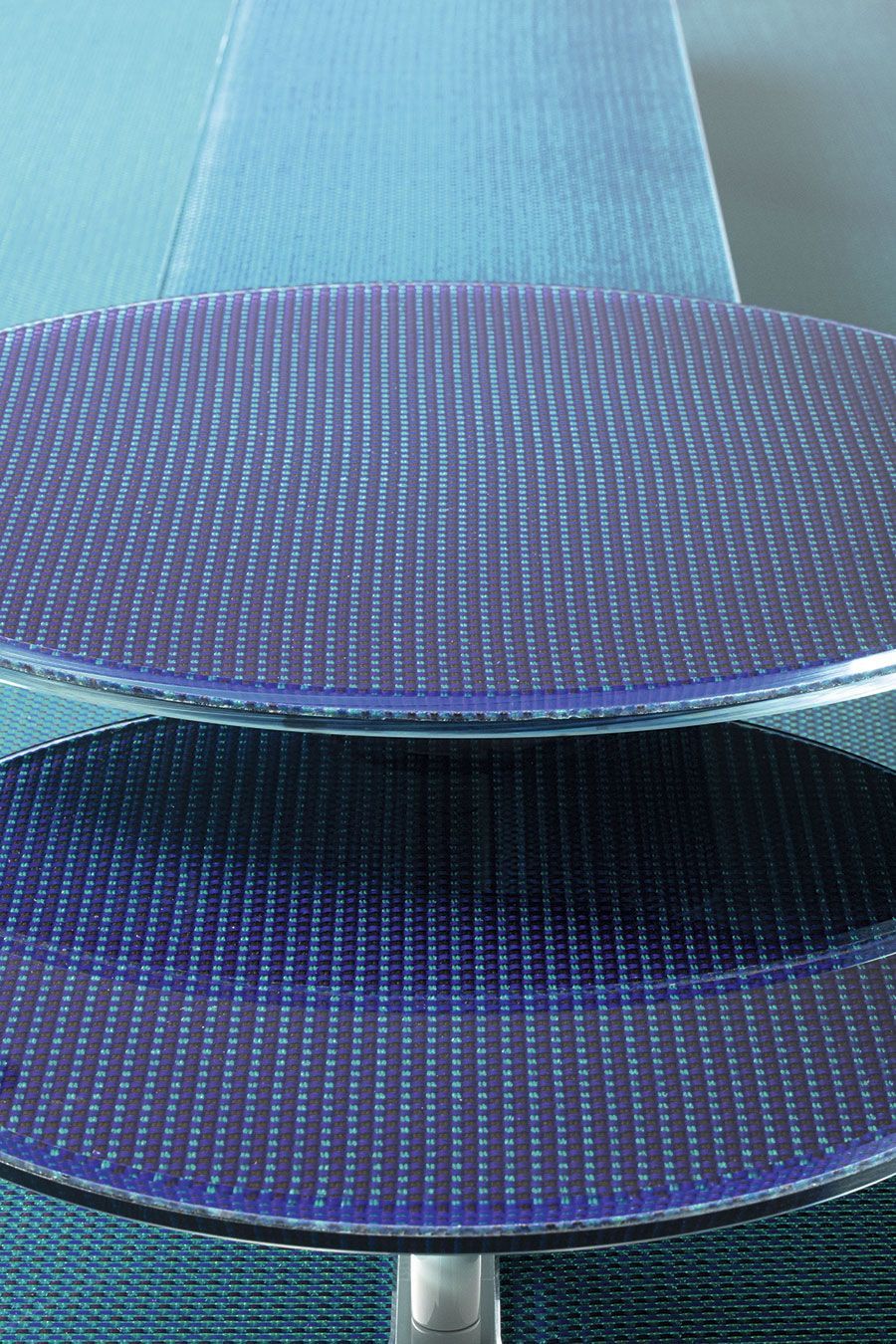 Primer plano de dos asientos de silla perforados de color azul apilados verticalmente.