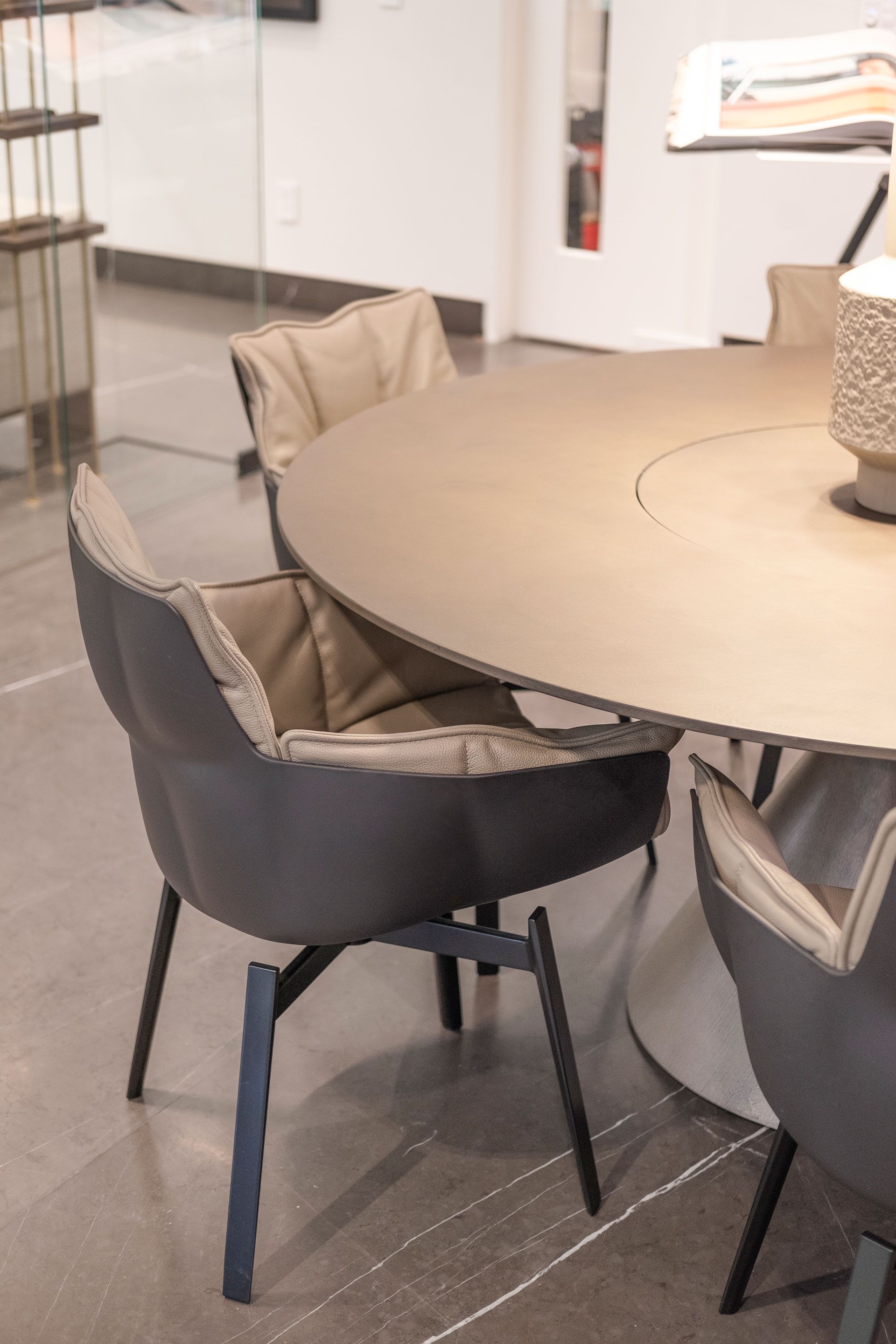 Mesa redonda con sillas gris oscuro en una sala de reuniones moderna.