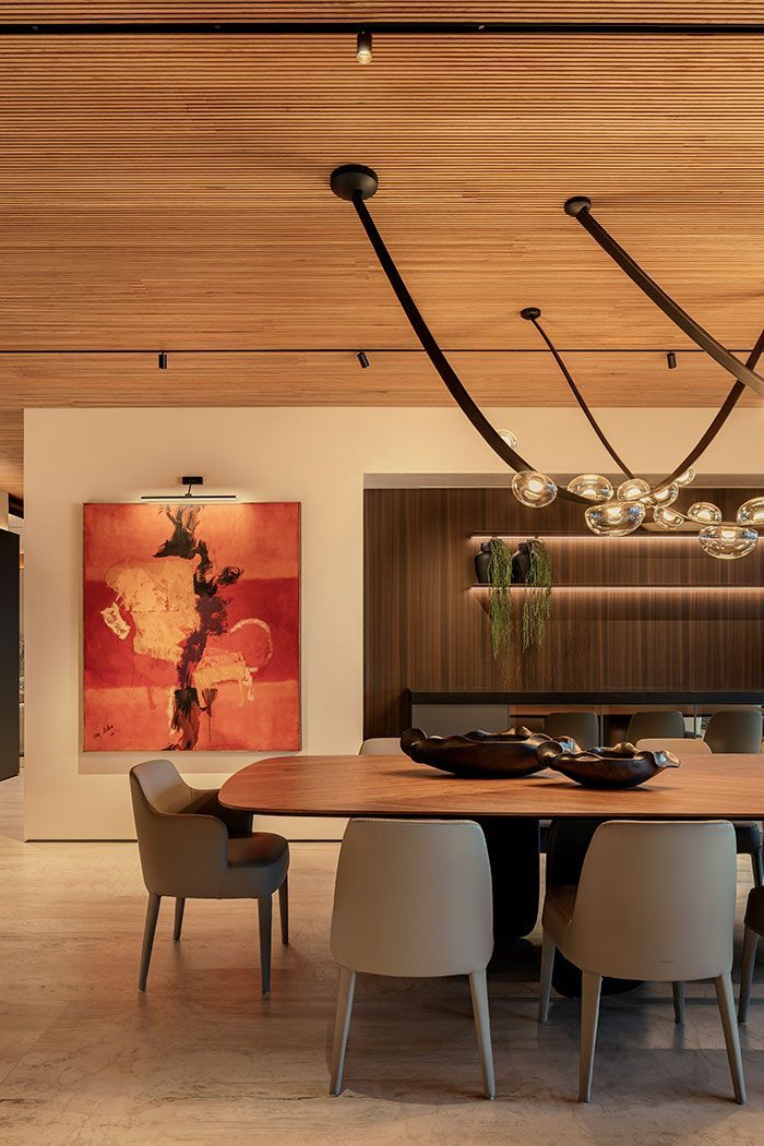 Sala de conferencias moderna con una mesa larga de madera, sillas color canela, aplique de pared y pared decorativa