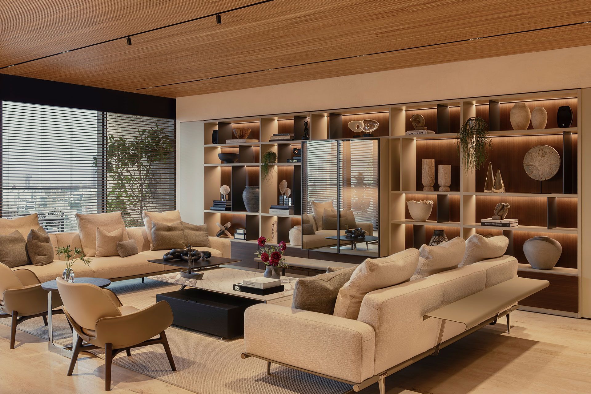 Salón moderno con sofá gris, revestimiento de madera y grandes paneles divisorios corredizos de madera.