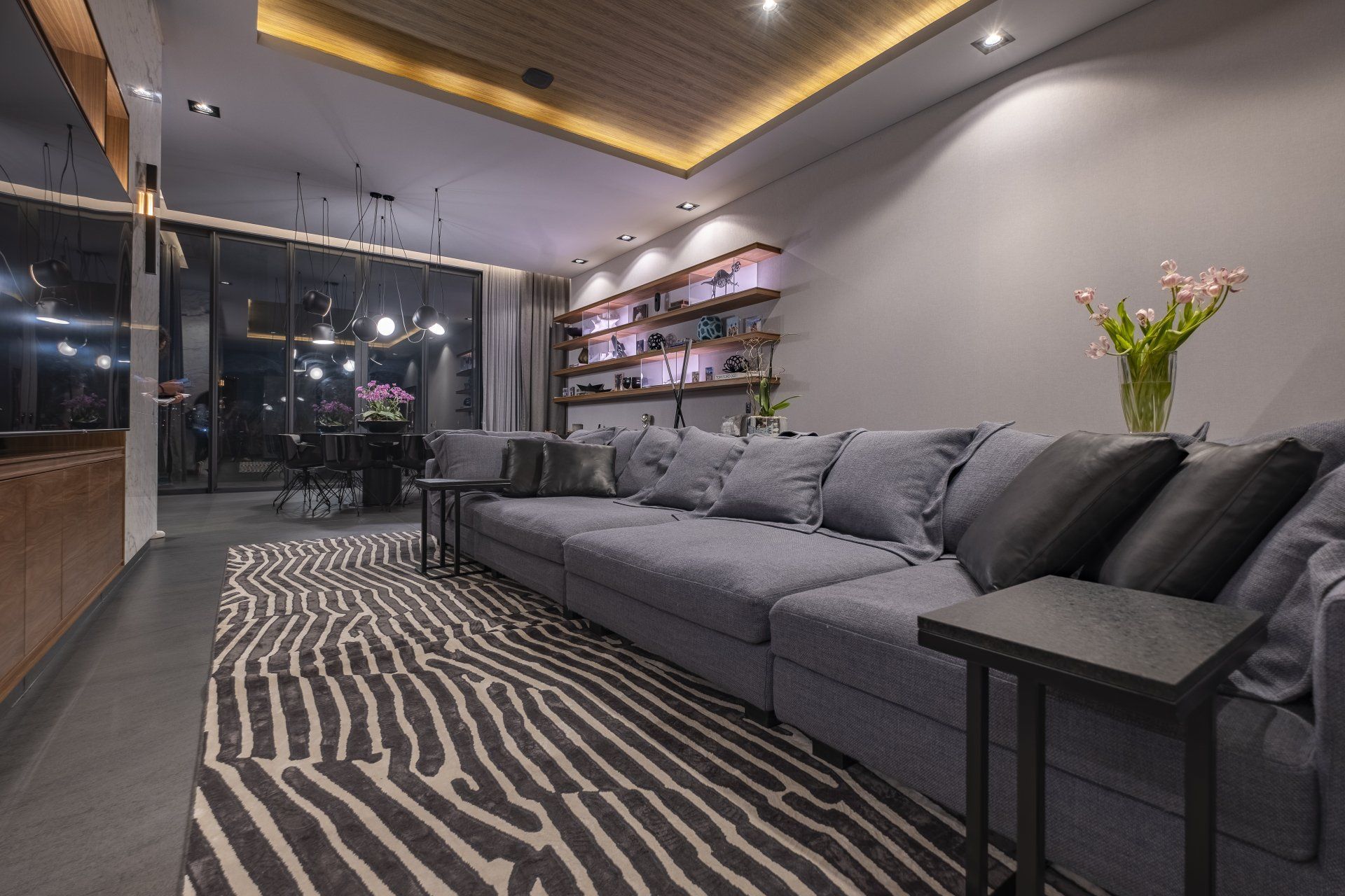 Sala de estar moderna con sofá seccional gris, alfombra a rayas