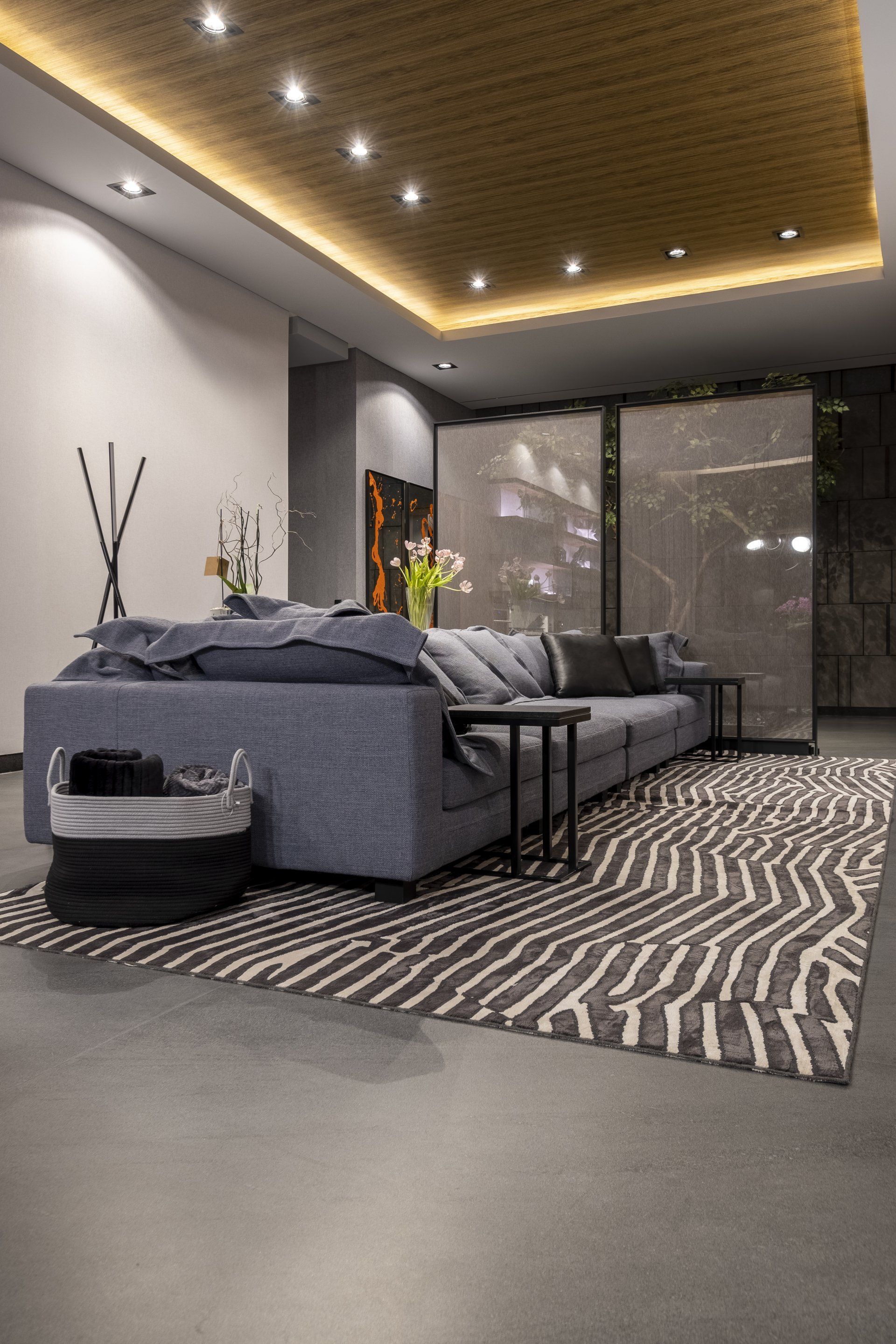 Sala de estar moderna con sofá seccional gris, alfombra estampada