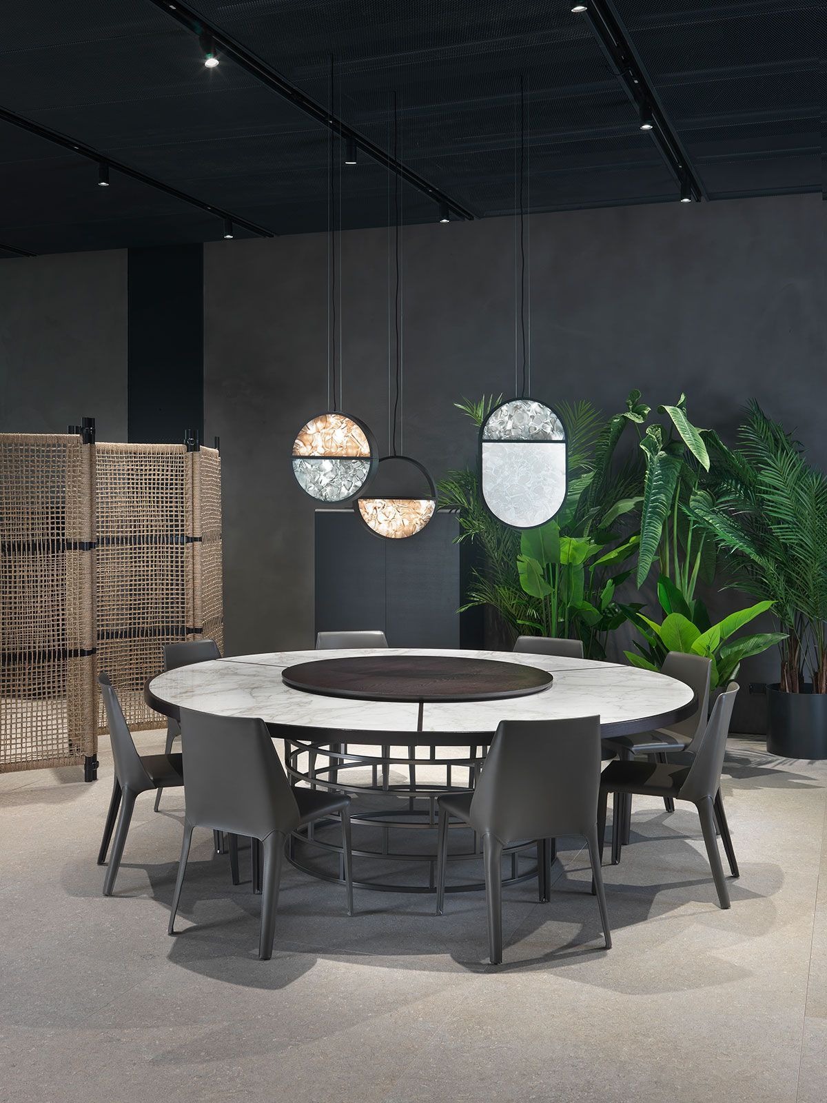 Conjunto de comedor moderno para exteriores con mesa redonda blanca, sillas grises, luces colgantes y plantas verdes 