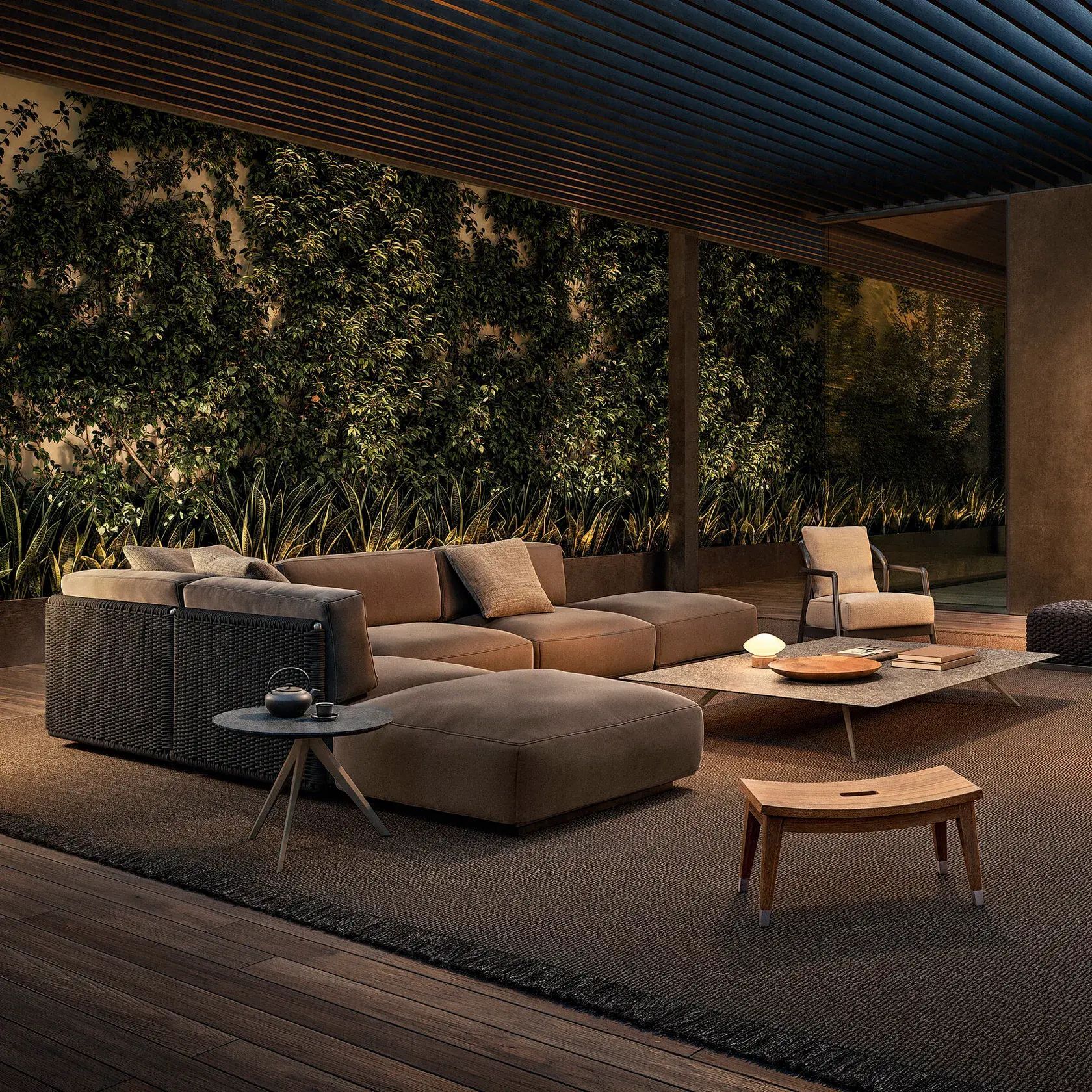 Salón exterior moderno con sofá modular, sillas, mesa de centro y una exuberante pared vegetal bajo un techo de listones.