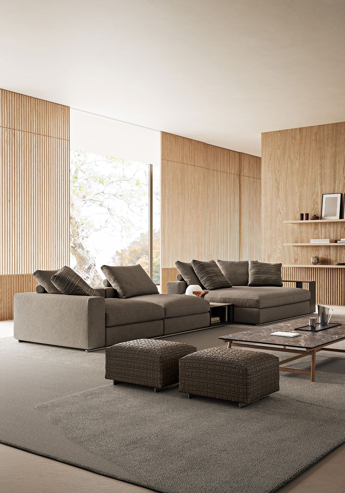 Sala de estar moderna con sofá seccional beige, alfombra gris y grandes ventanales con cortinas.