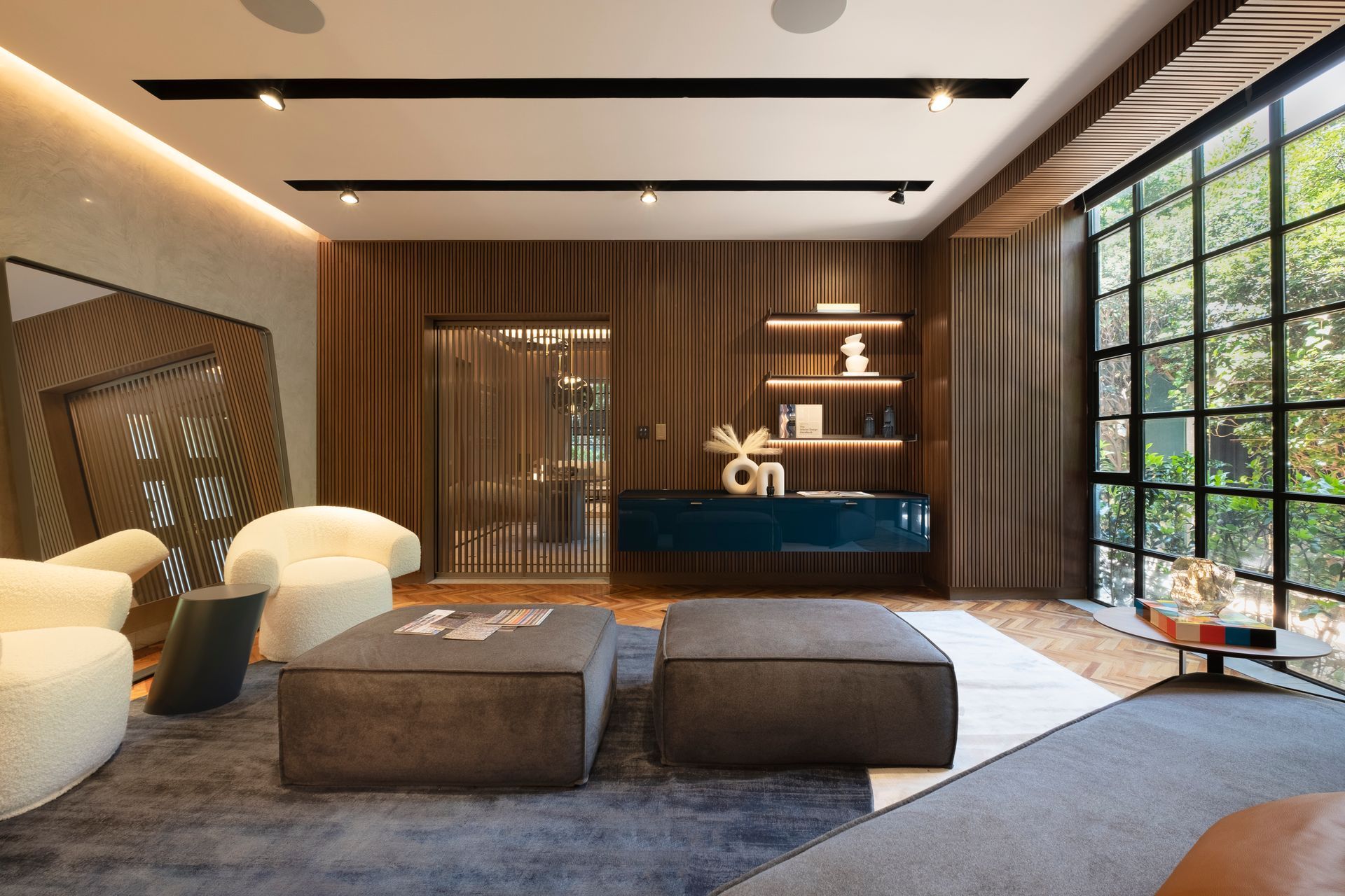 Moderna sala de estar de lujo con sofá modular, otomana, paneles de madera en las paredes y grandes ventanales