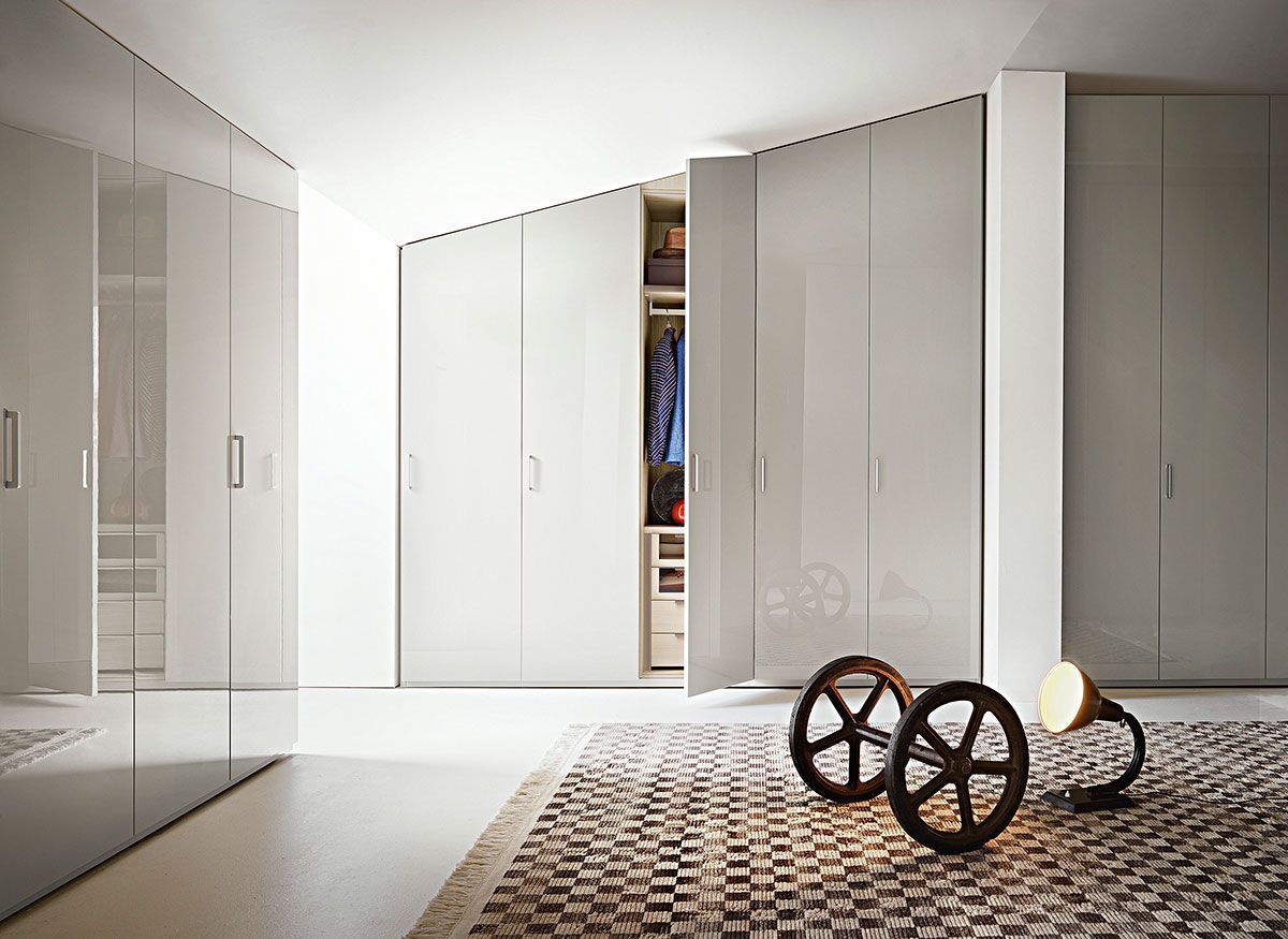 Dormitorio moderno de color blanco con armarios empotrados, armario abierto y una pequeña escultura decorativa