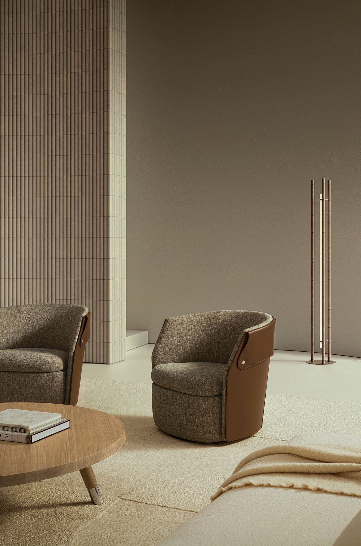 Sala de estar minimalista con sillas marrones, mesa de centro tejida y decoración en color beige sobre una pared color topo.