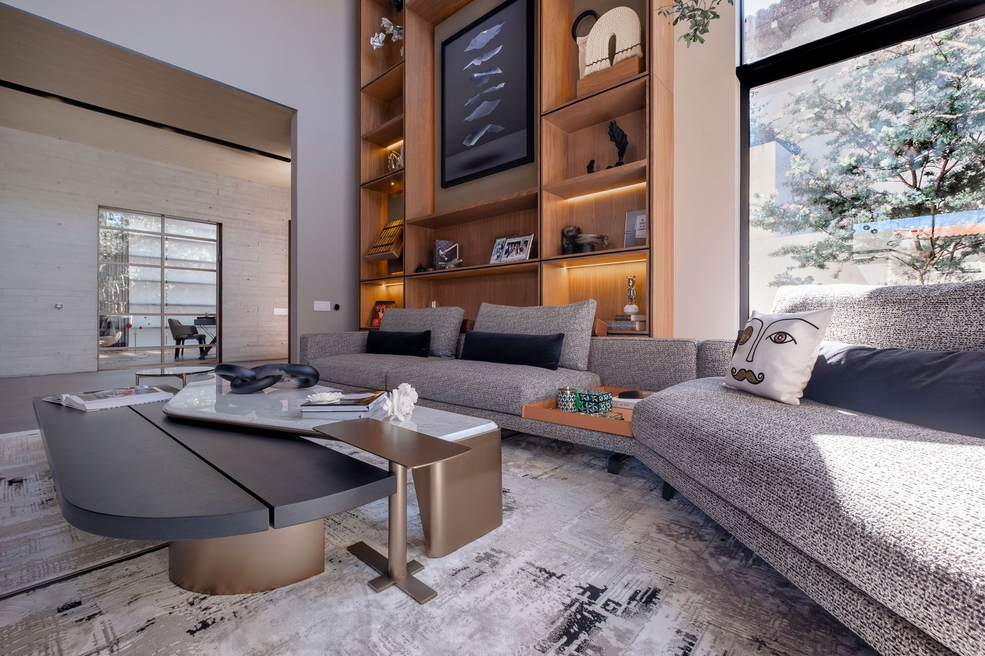 Sala de estar moderna con un gran sofá modular, una mesa de centro baja, chimenea y ventanales que van del suelo al techo.