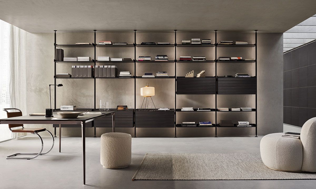 Sala de estar moderna y minimalista con una larga estantería, escritorio, sofá de color neutro