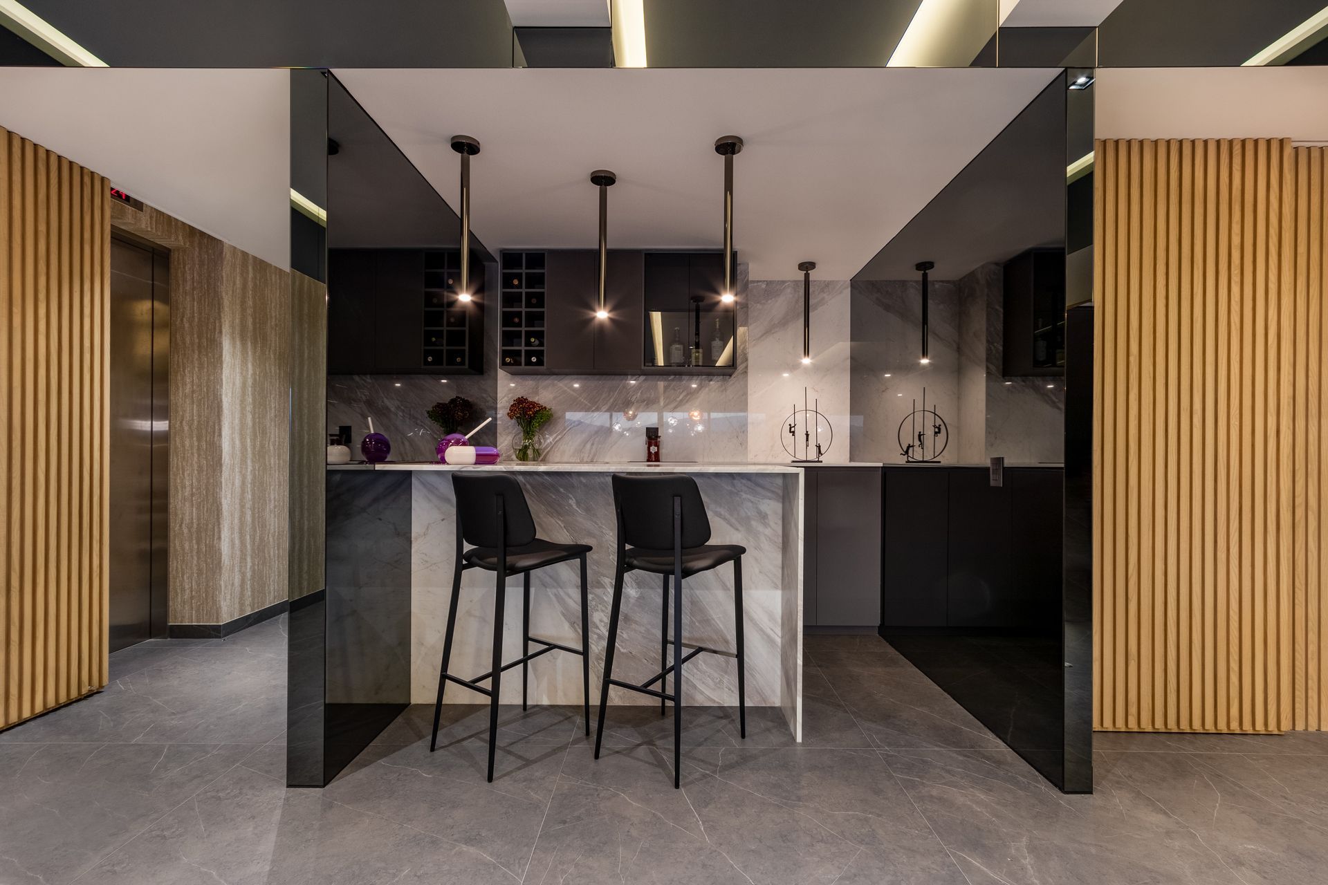 Cocina moderna de oficina con encimera de mármol, taburetes de bar, lámparas colgantes