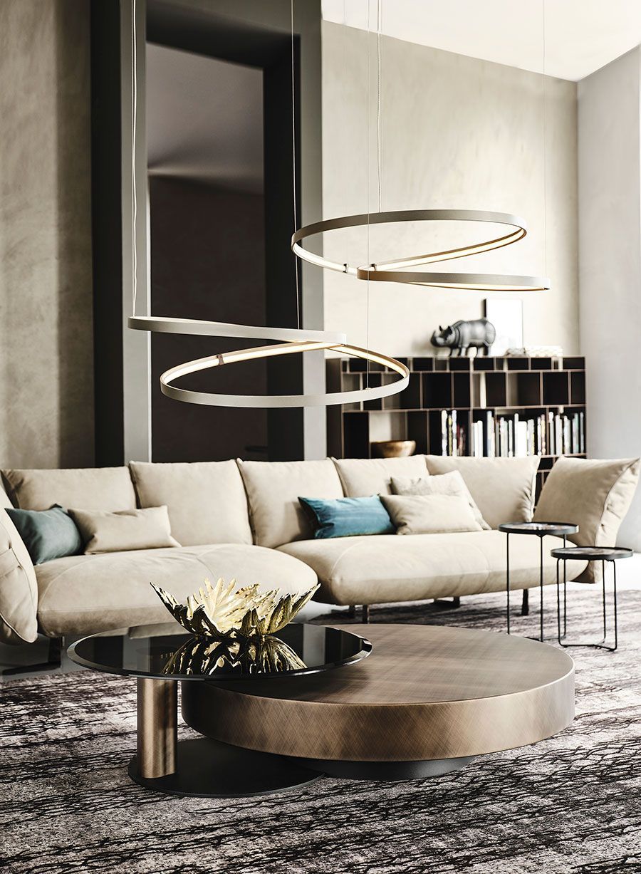 Sala de estar moderna con sofá seccional beige, mesas de centro redondas, lámparas colgantes circulares