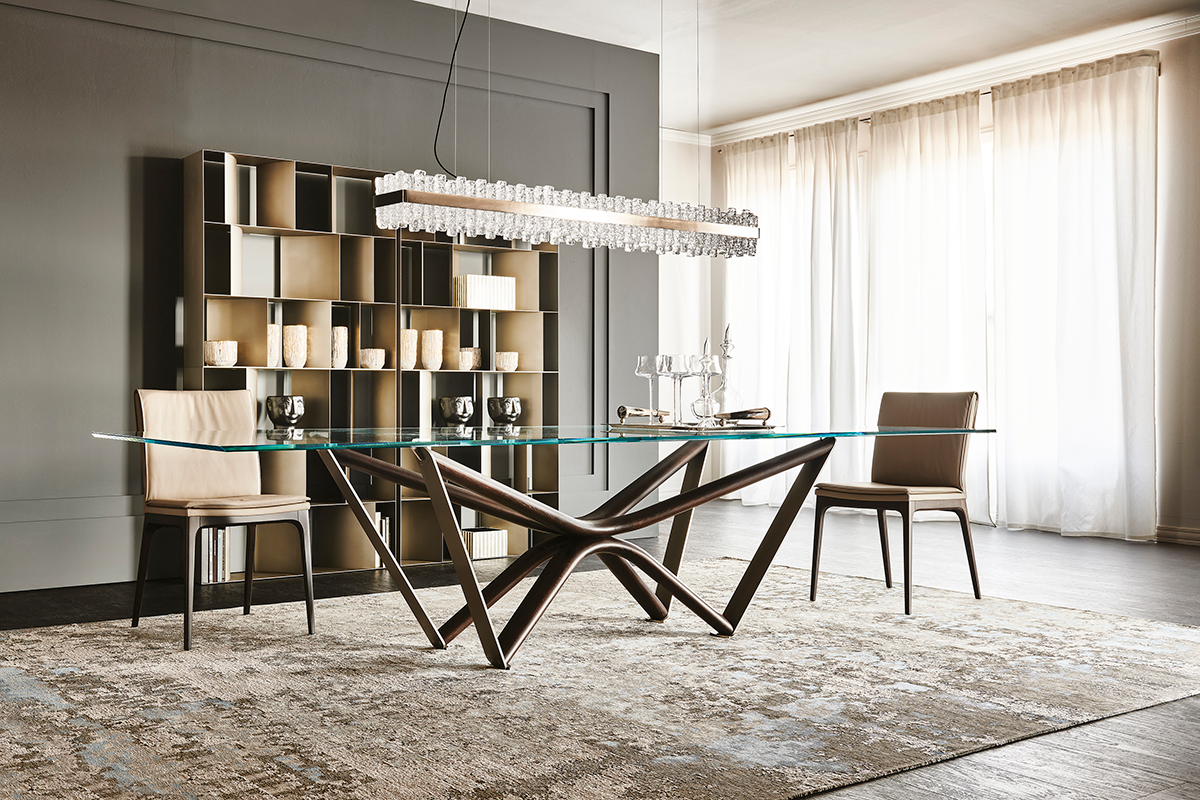 Comedor moderno con mesa de cristal, cuatro sillas, estanterías de pared con espejos y una alfombra grande