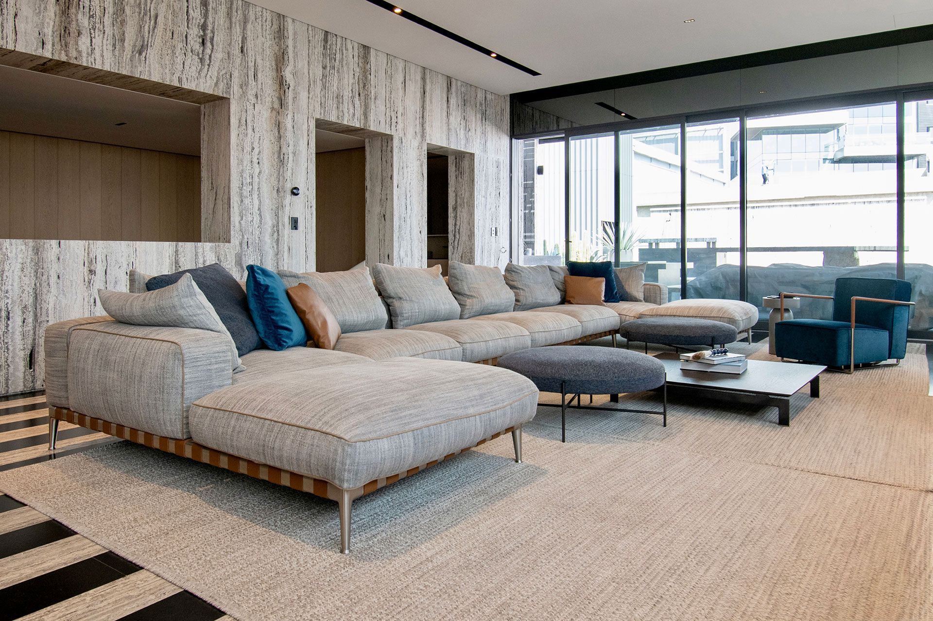 Sala de estar moderna con estantes iluminados empotrados, listones de madera verticales y un sofá gris claro.