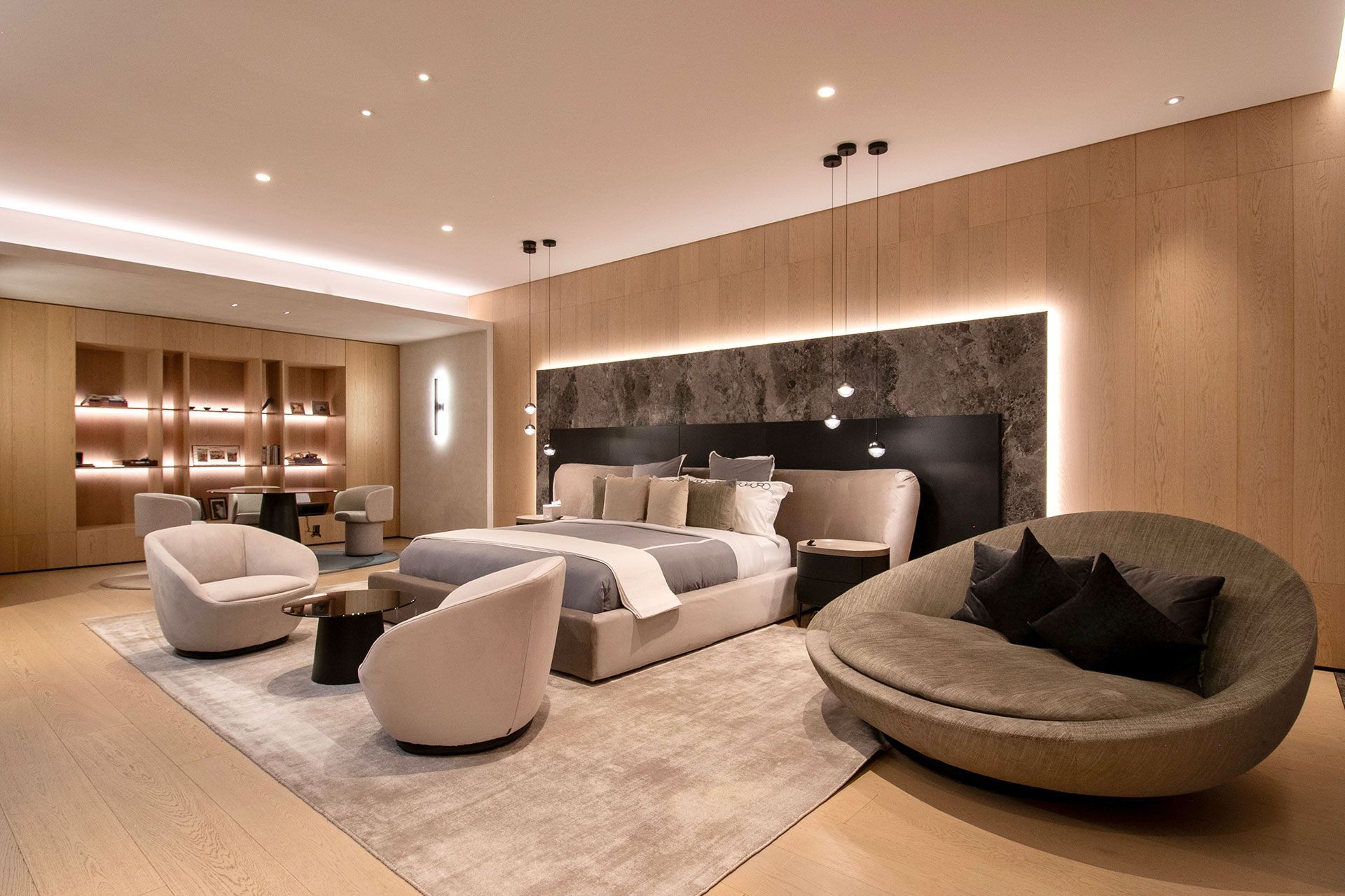 Salón-comedor moderno con sofá gris, mesa larga de madera y luces de la ciudad por la noche.