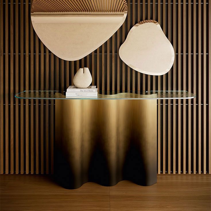 Mesa consola moderna con tablero de cristal, base dorada y arte abstracto en la pared