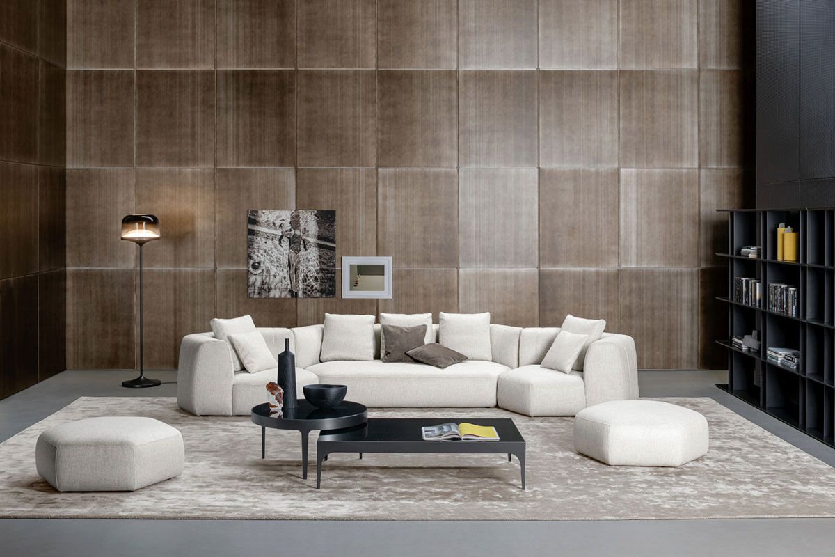Sala de estar moderna con sofá modular beige, mesa de centro, lámpara de pie, alfombra y estanterías