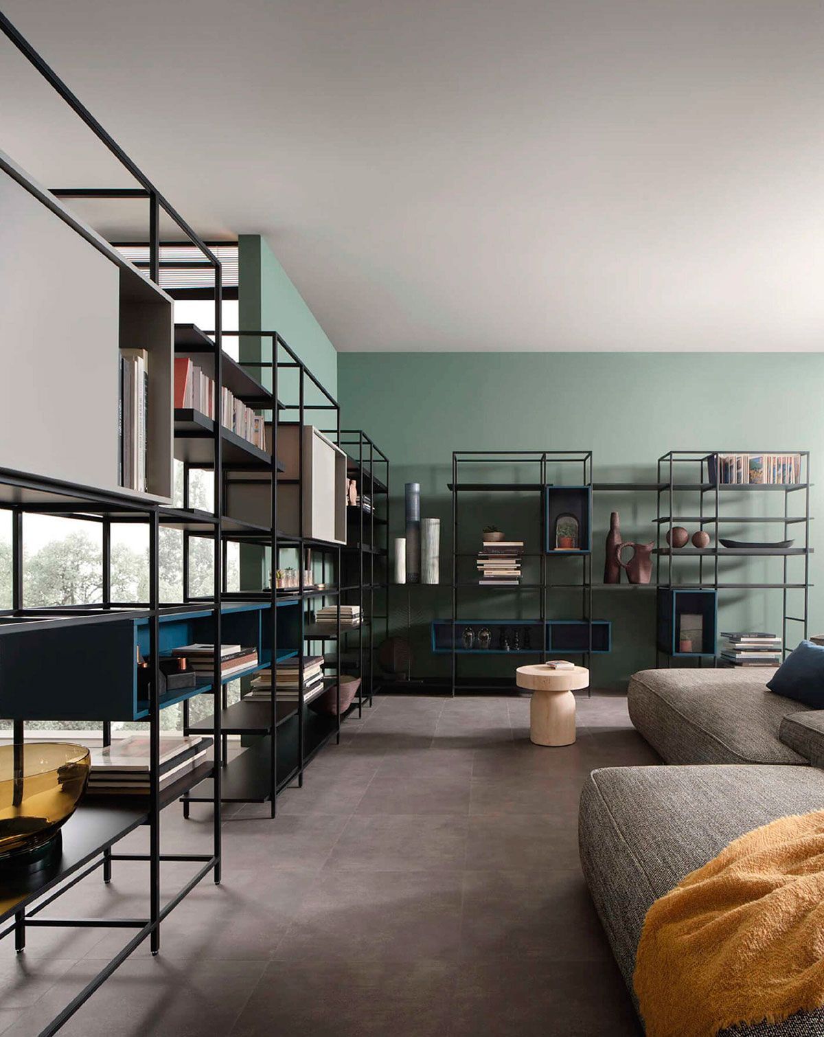 Sala de estar moderna con estanterías negras, sofá gris y pared decorativa color menta.