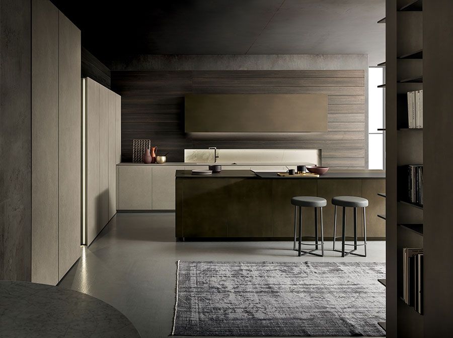 Cocina moderna minimalista con gabinetes de madera oscura, isla, taburetes y alfombra gris.