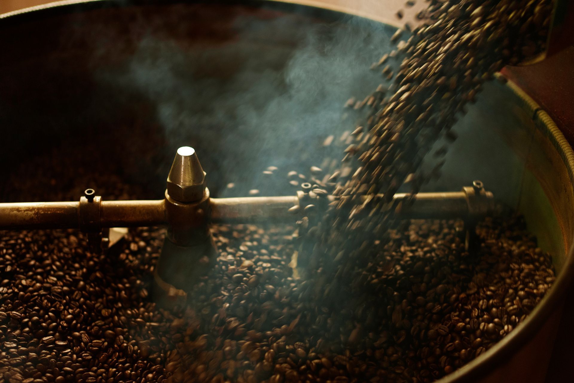 I chicchi di caffè vengono versati in una macchina tostatrice.