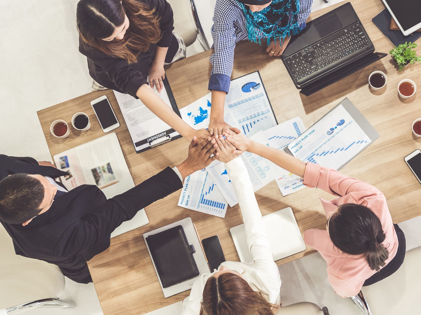 Team members reaching hand