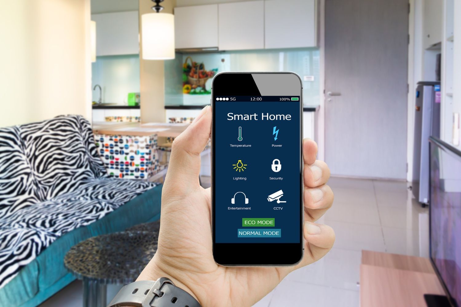 A hand holds a smartphone displaying a smart home control app against the backdrop of a modern living room.