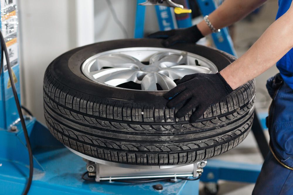 A Mechanic Mounting Tire on Machine in Garage — Jakes Tyres in South Murwillumbah, NSW