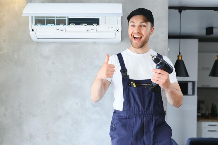 Smiling AC technician giving thumbs up during air conditioning installation