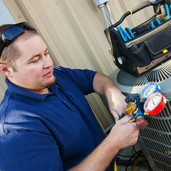 HVAC technician checking AC system with gauges for affordable repair and financing options
