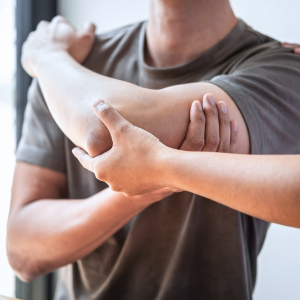 Person holding an elbow, suggesting arm pain or injury