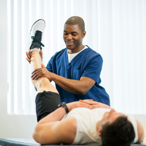 Physical therapist stretching a patient’s leg in a clinic, with the patient lying on a treatment table