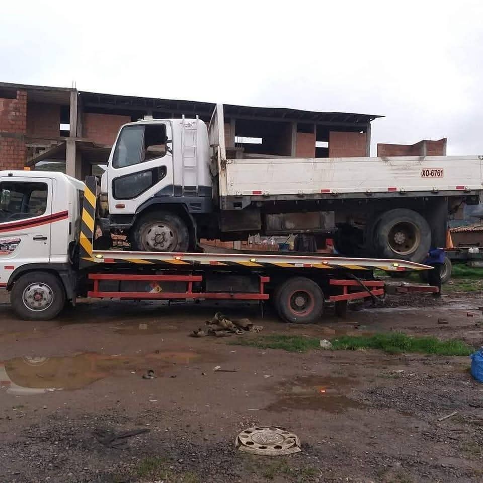 Una grúa con plataforma está estacionada frente a un edificio.