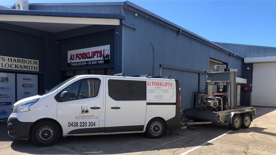 White Van Towing a Machine Trailer in Front of a Blue Building — A1 Forklifts In Taree, NSW
