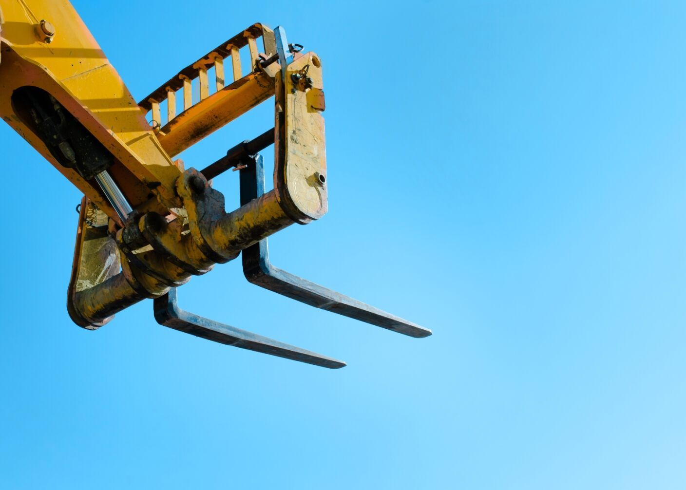 Yellow Forklift Forks Against a Bright Blue Sky — A1 Forklifts In Wauchope, NSW
