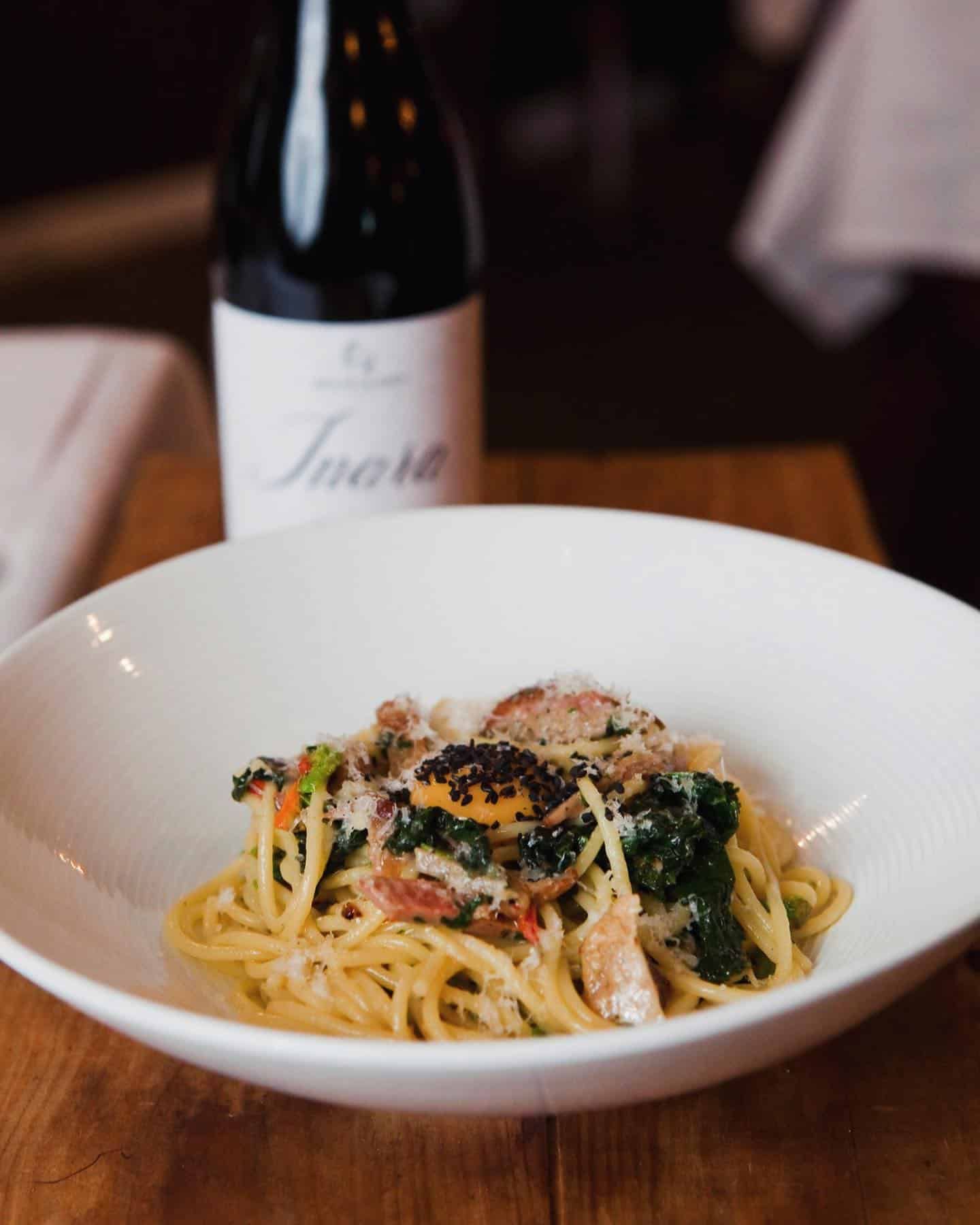 A Bowl of Spaghetti With a Bottle of Wine in the Background — Onesta Cucina in Bowral, NSW