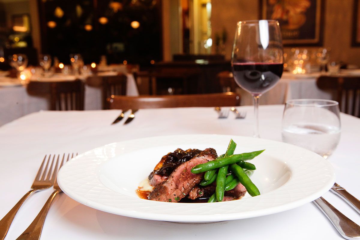 A Plate of Food and a Glass of Wine on a Table — Onesta Cucina in Bowral, NSW