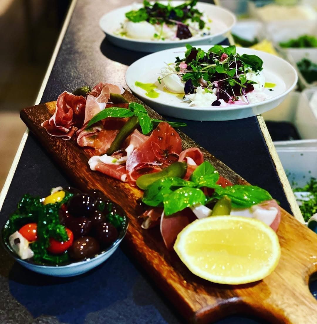 A Wooden Cutting Board Topped With Meat and Vegetables — Onesta Cucina in Bowral, NSW