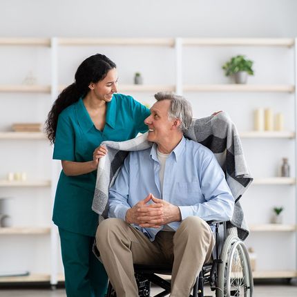 Woman Helping Elder Man On Wheelchair