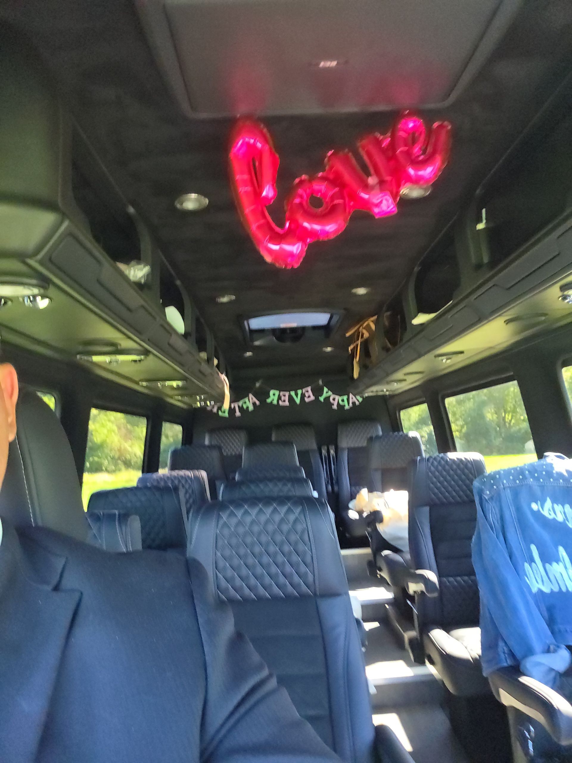 A view inside a decorated passenger van with black leather seats, a