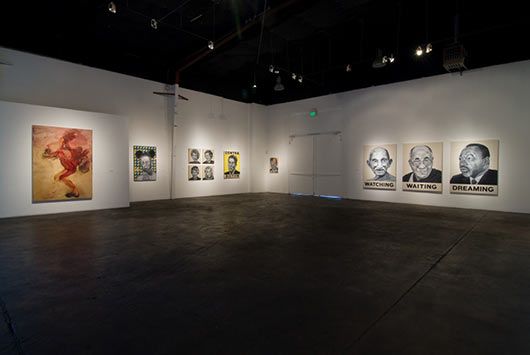 A large empty room with a lot of paintings on the walls.