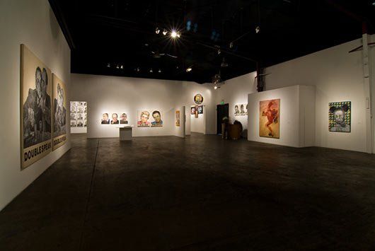 A large empty room with a lot of paintings on the walls.
