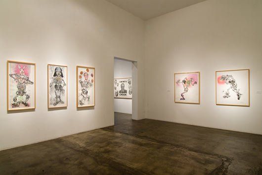 A room with a lot of paintings on the wall.