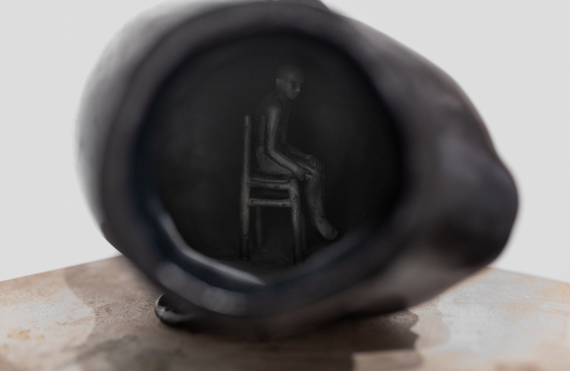 A close up of a black object with a drawing of a chair on it.