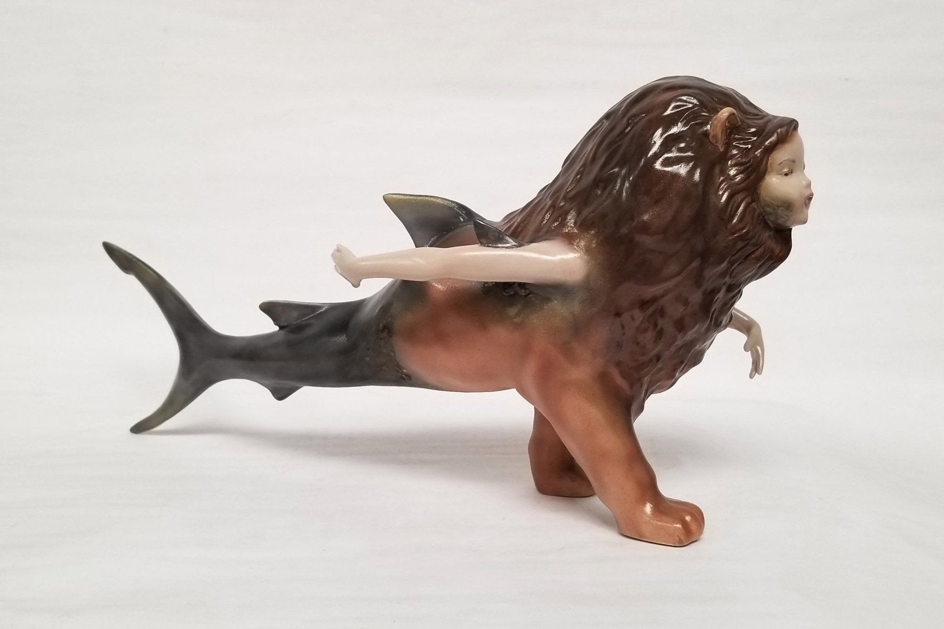A statue of a lion with a mermaid on its back