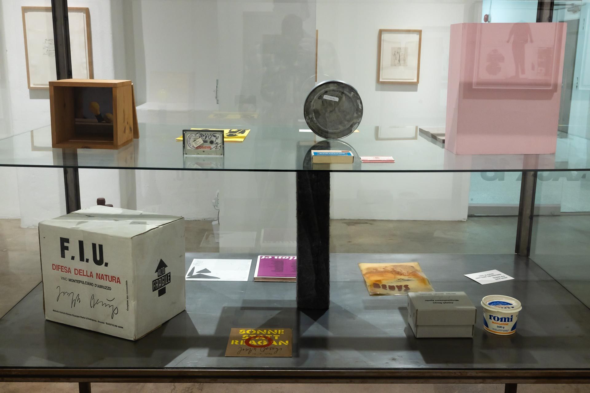 Museum display case with assorted small objects and labels on glass shelves. TRACK 16 | DOWNTOWN LA art exhibition and retrospective of JOSEPH BEUYS titled POTENTIAL GOODS. Sculpture, mixed media and drawings.