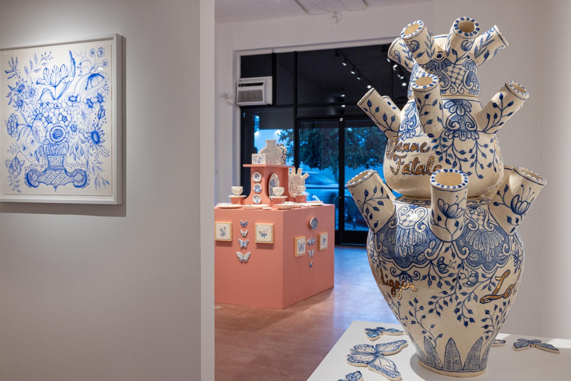Art gallery with blue-and-white ceramic sculpture and matching artwork on walls, displayed on pink pedestals. Elyse Pignolet art exhibition at Track 16 East Hollywood gallery. Title, The Revolution Will Not Be Televised featuring ceramic works and drawings.