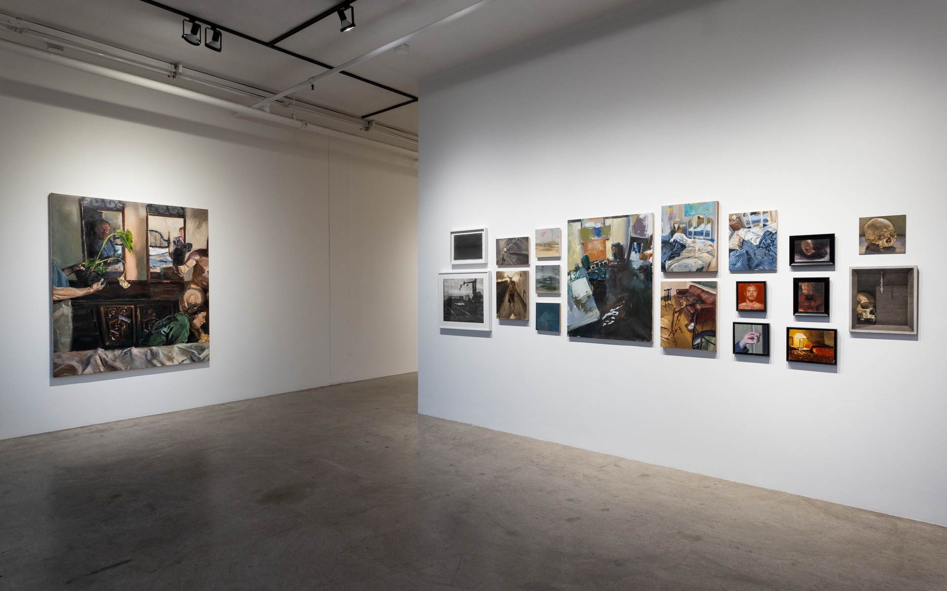 Figure painting at left and a salon-style cluster of small paintings and framed works on the white wall at right. Installation view, Frank Ryan: Lived Perspective, Track 16.
