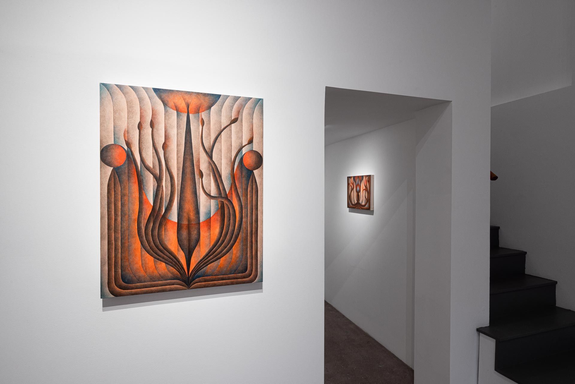 Orange and white painting beside a stairwell, a second painting through the doorway. Installation view, Roberta Gentry: Blood Orange, Track 16, Los Angeles.